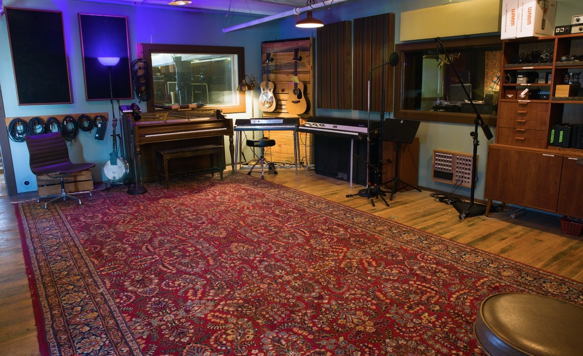 a spacious room with a piano and Wurlitzer