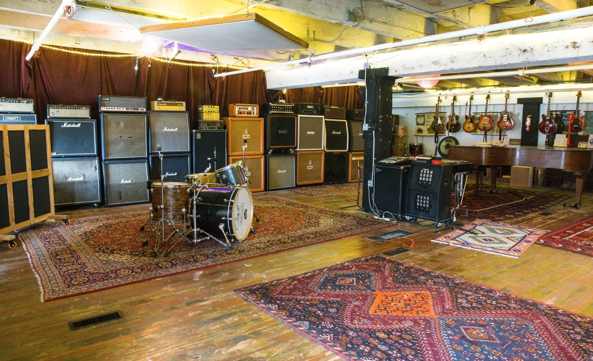 a wide rehearsal space with dozens of amps against the wall